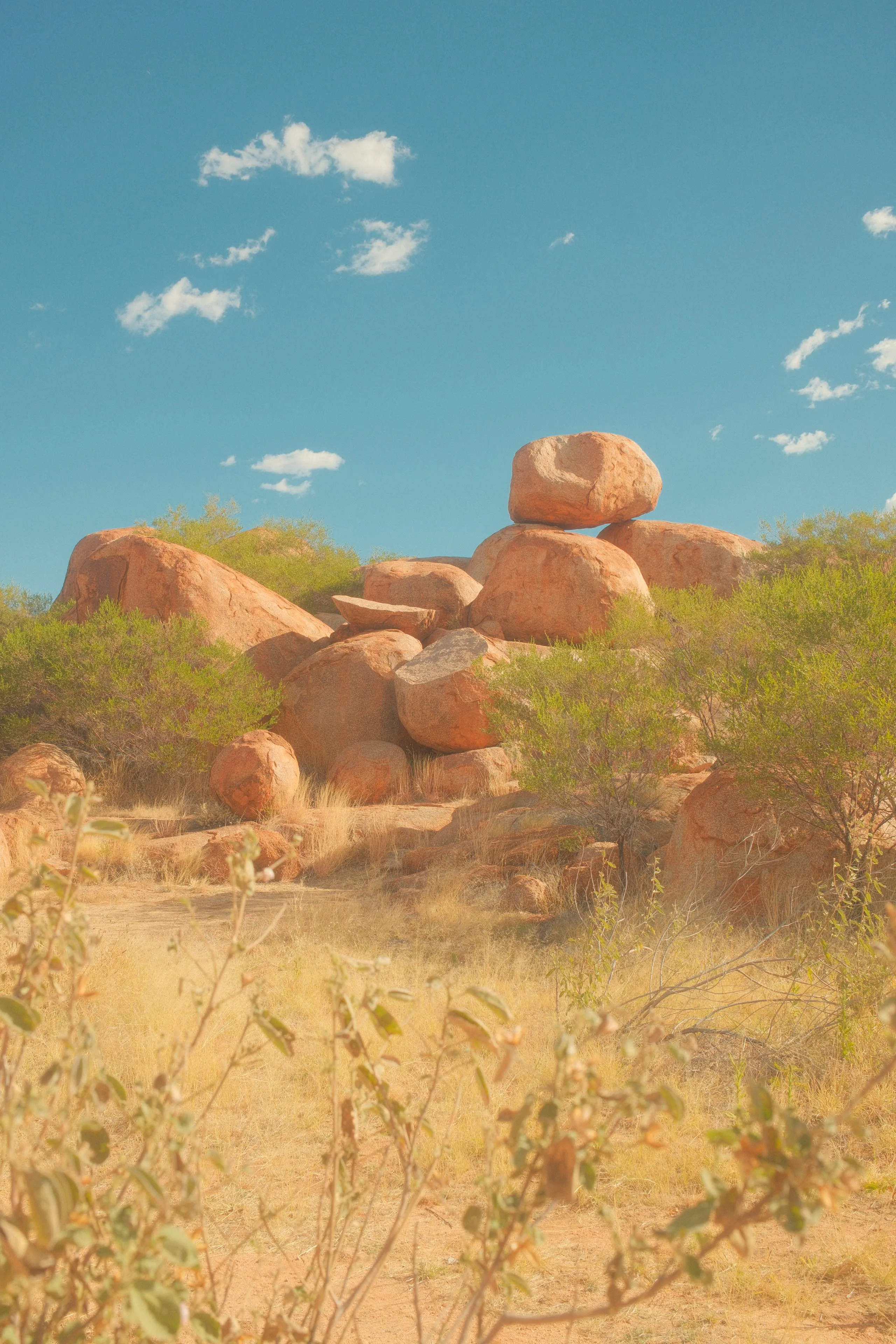 Large rounded red granite boulders stacked on top of each other under a blue sky